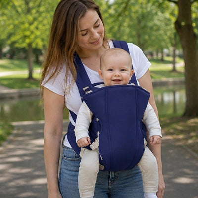 maman avec bébé en porte bebe ergonomique vent au parc