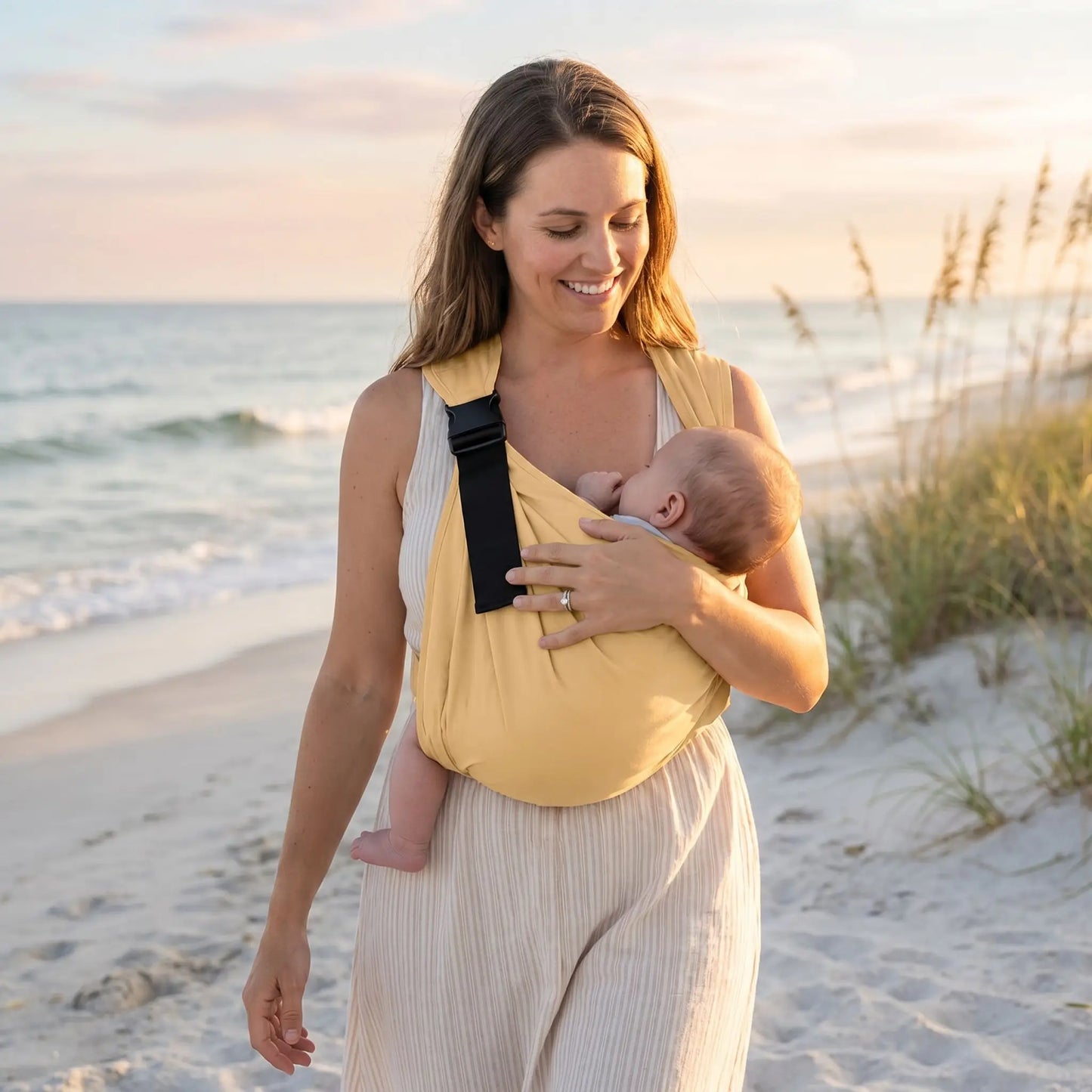 maman porte bébé dans l'echarpe de portage été ergocarry sur la plage