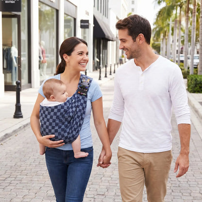 maman porte bébé dans porte bebe echarpe ergobaby avec papa en ville