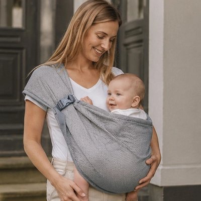maman porte bébé en echarpe portage été vive devant la maison