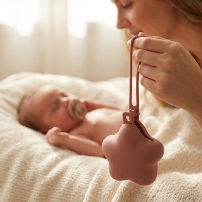 maman porte la boite a tetine nomade avec bébé au lit