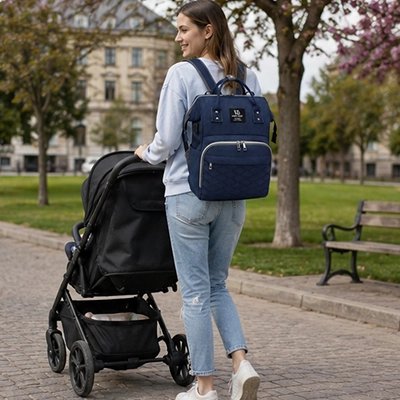 maman porte sac a langer impermeable avec bébé au parc