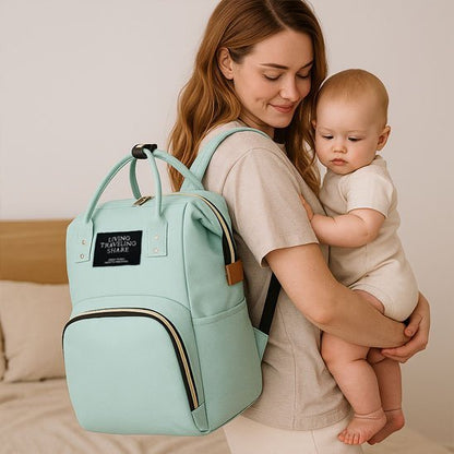 maman porte le sac à langer pratique & élégant vert au dos bébé dans la chambre