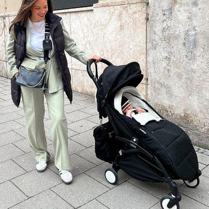  Maman avec bébé dans la chancelière poussette ultra  isolante marche au bord des maisons
