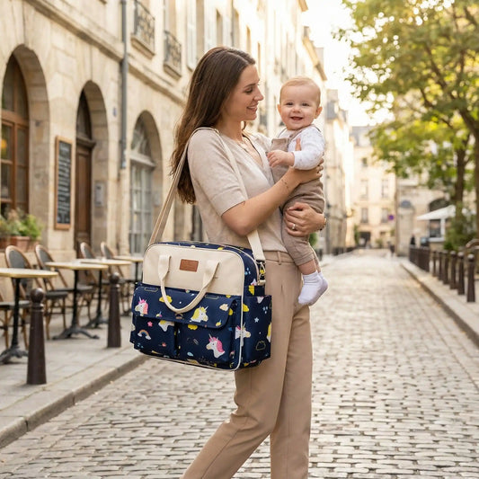 maman porte sac à langer bébé harmony sur l'épaule et tient bébé dans ses bras