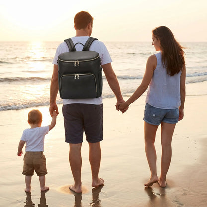 papa porte sac a langer chic cuir mompratique au dos  sur la plage avec bébé et maman