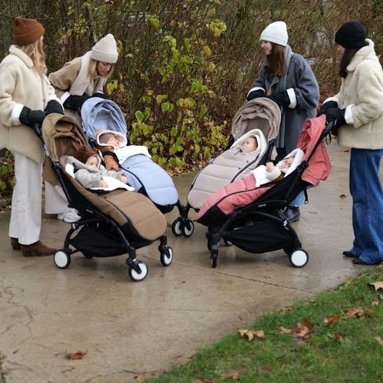 plusieurs mamans qui parlent en regardant leurs bébés dans les chancelières poussette ultra isolante au parc