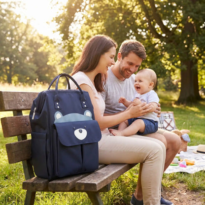 sac a dos a langer chic mombear sur le banc au parc avec bébé et sa famille