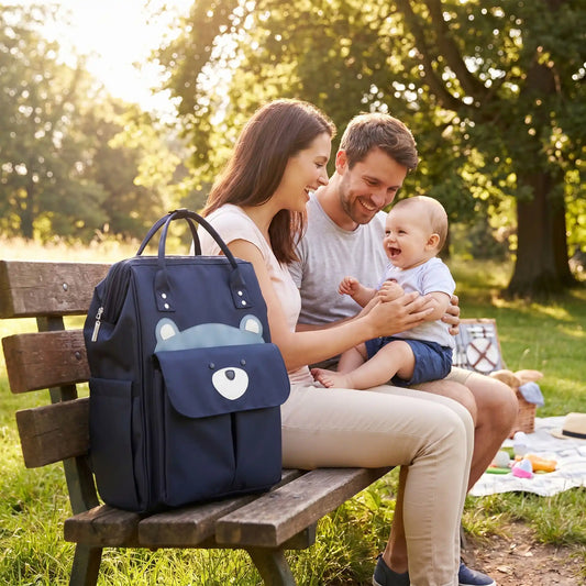 sac a dos a langer chic mombear sur le banc au parc avec bébé et sa famille