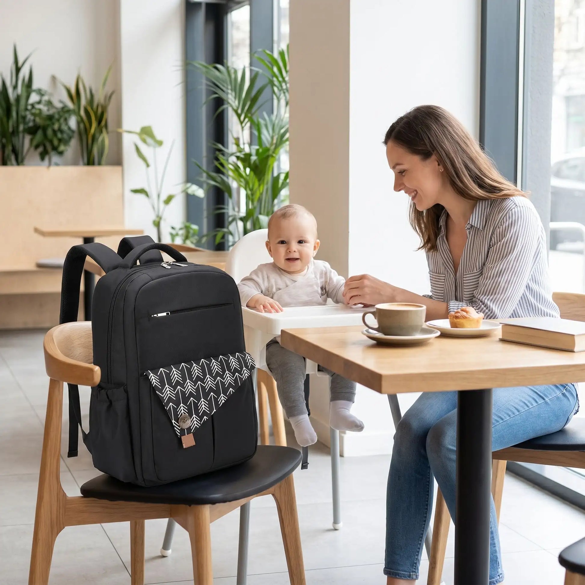 sac a langer baby chic mommystar sur une chaise au café restaurant avec maman et bébé