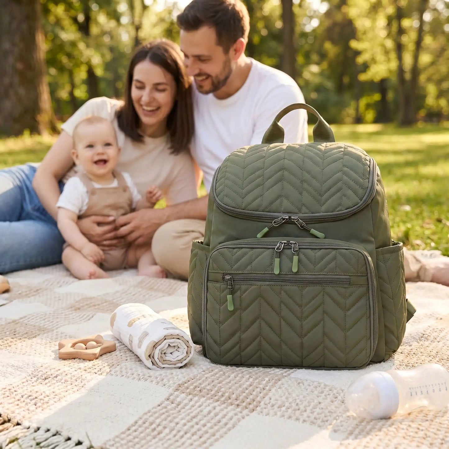 sac a langer bebe impermeable green sur la couverture au parc a cote de bébé et sa famille
