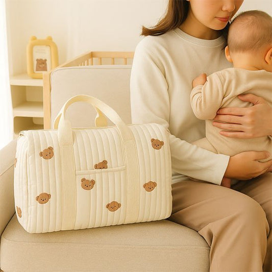sac a langer bebe multifonction dans le fauteuil à coté de  maman et bébé