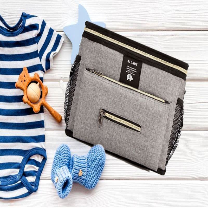 sac a langer grand babytravel gris avec essentiel de bébé sur un banc