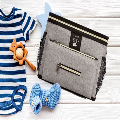 sac a langer grand babytravel gris avec essentiel de bébé sur un banc