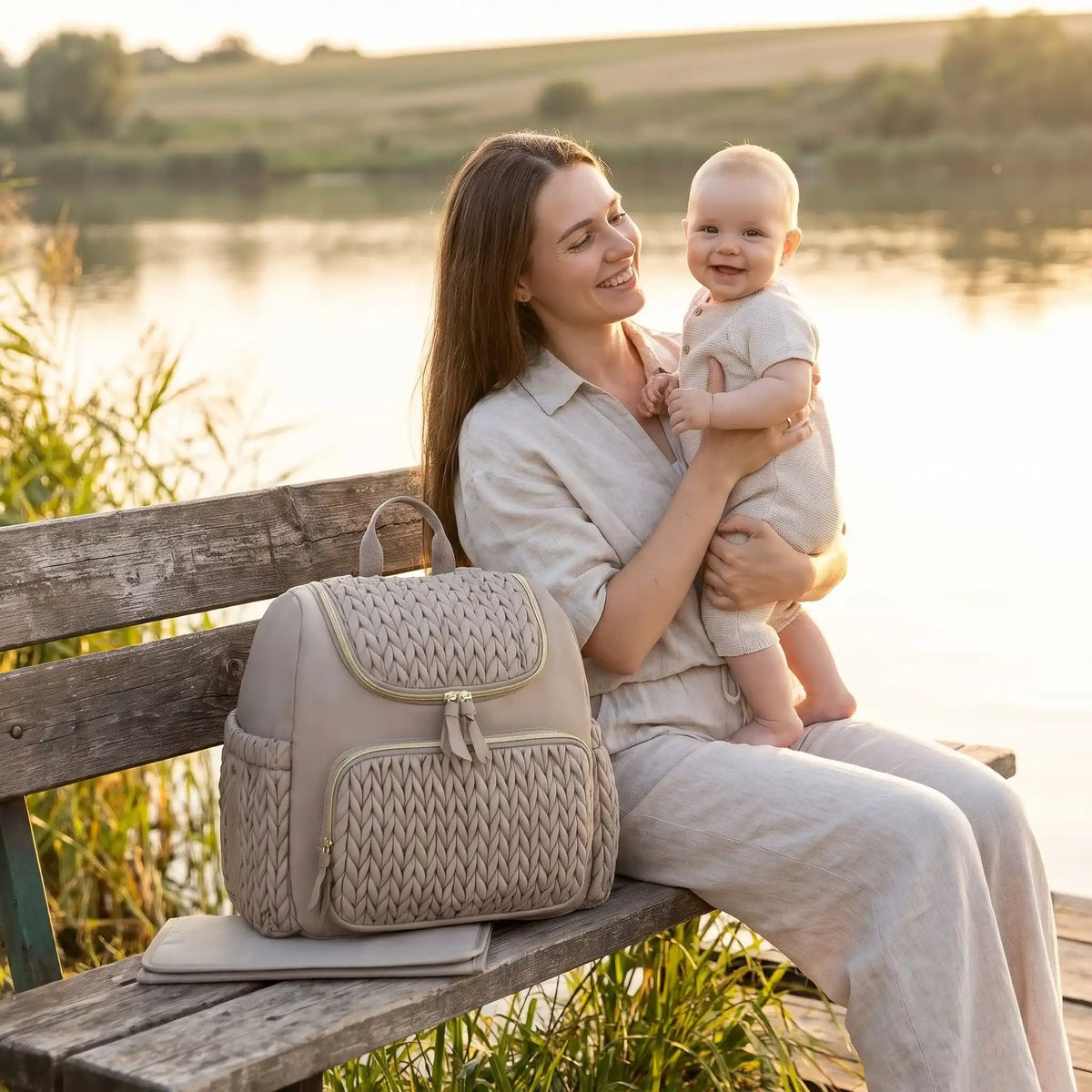 sac a langer gris finesse sur le banc avec bébé et maman