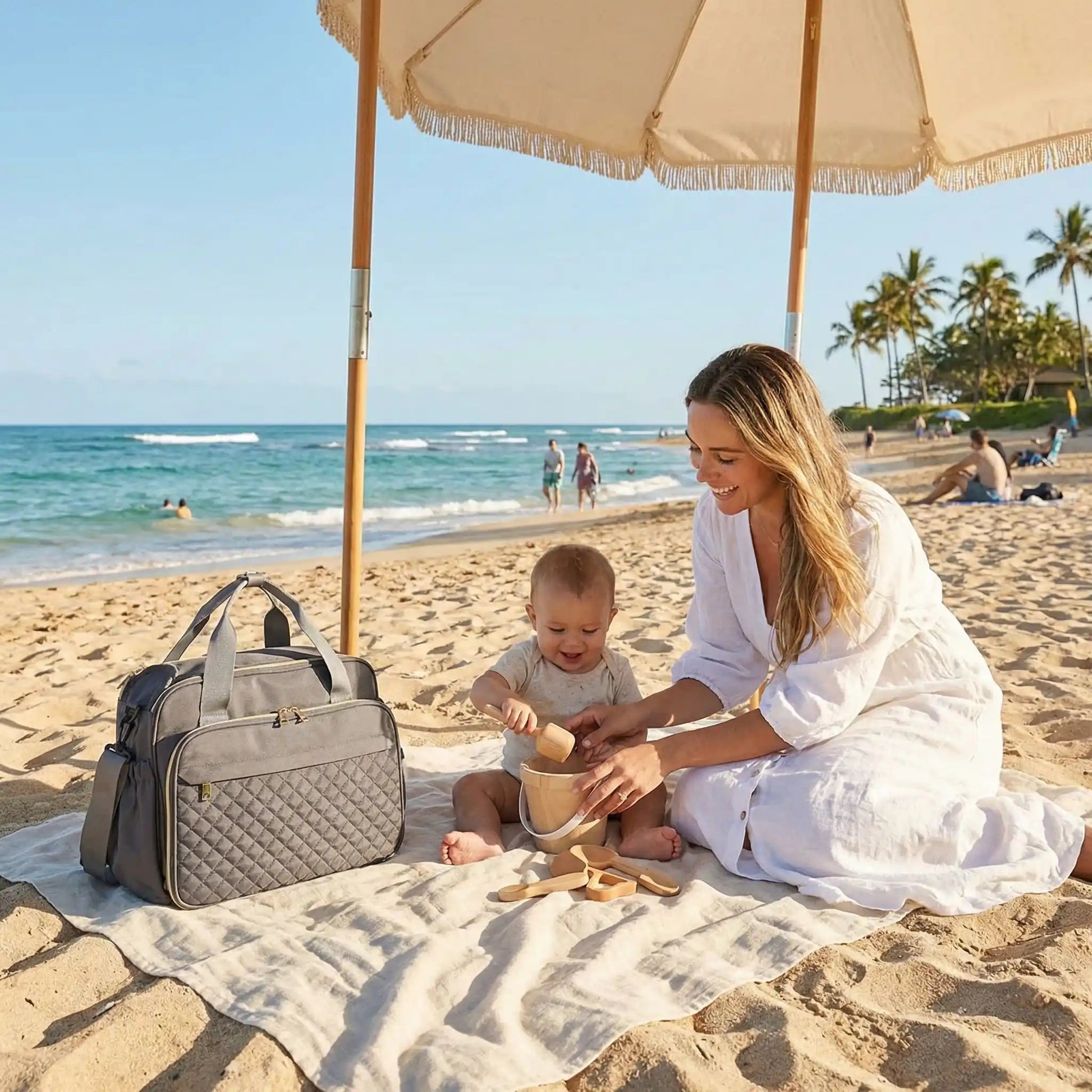 sac a langer octopoche sur la couverture avec maman et bébé sur la plage