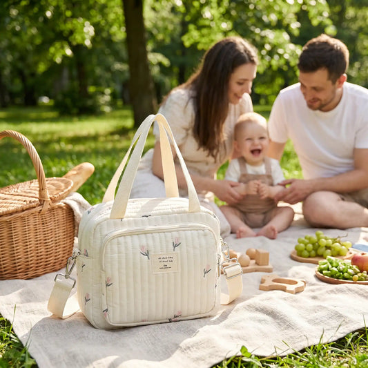sac a langer sport chic floral sur la couverture au parc avec bébé et sa famille